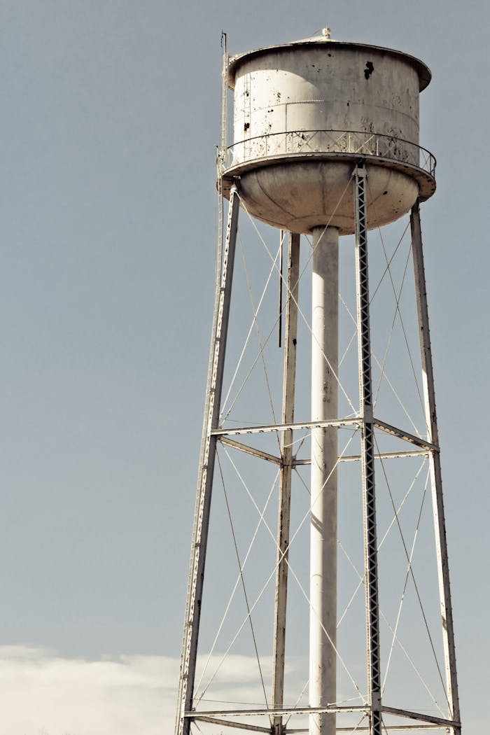 A tall, rustic water tower stands against a clear sky in Indiana, USA.